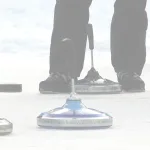 Mehrere Curlingsteine liegen auf einer Eisfläche, während Personen sie mit Curlingbesen spielen.